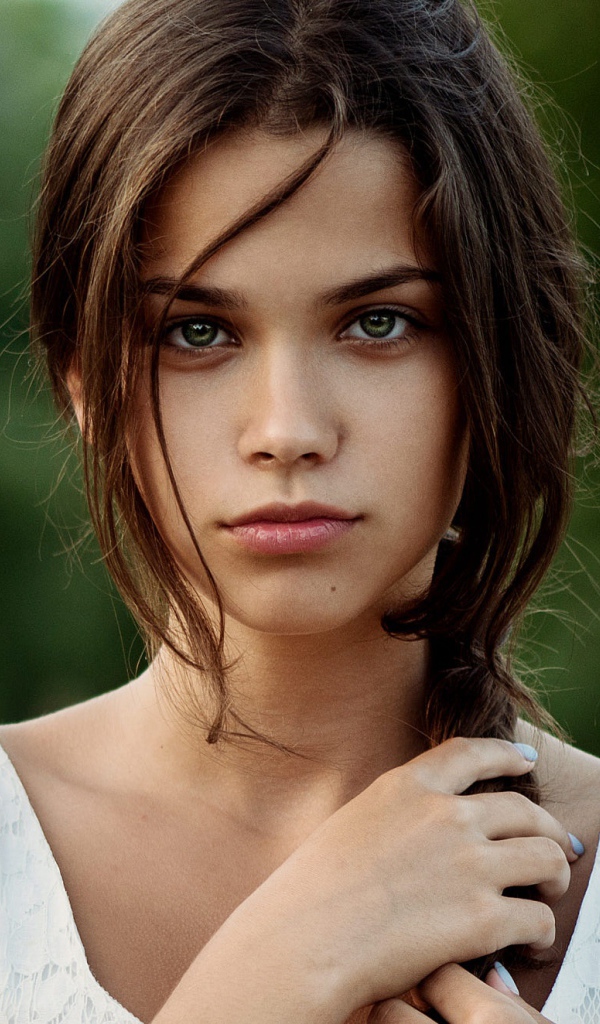 Красивая молодая зеленоглазая девушка с косой на голове