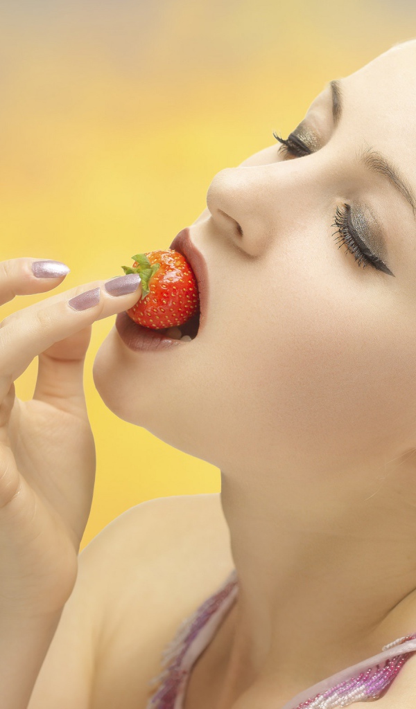 Девушка блондинка ест клубнику