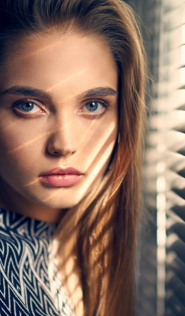 Девушка блондинка с голубыми глазами у окна 