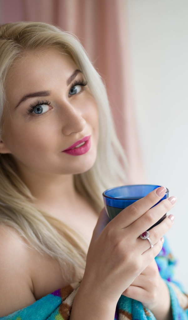 Блондинка с розовыми губами и стаканом в руках 