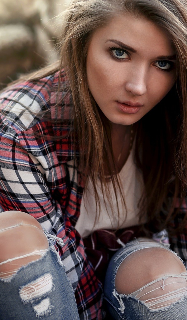 Голубоглазая девушка брюнетка в модных джинсах 