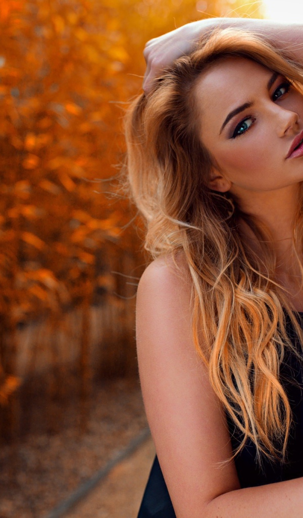 Голубоглазая девушка блондинка у стены 