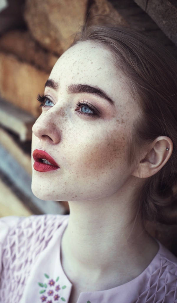 Голубоглазая девушка с веснушками на лице 