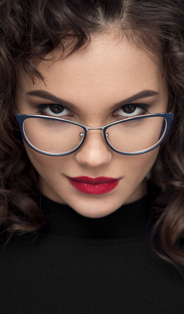 Брюнетка с красными губами с очками на лице