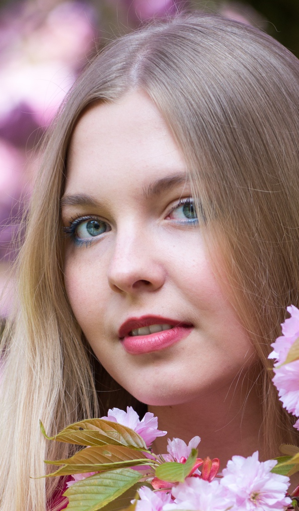 Милая голубоглазая девушка с розовыми цветами 