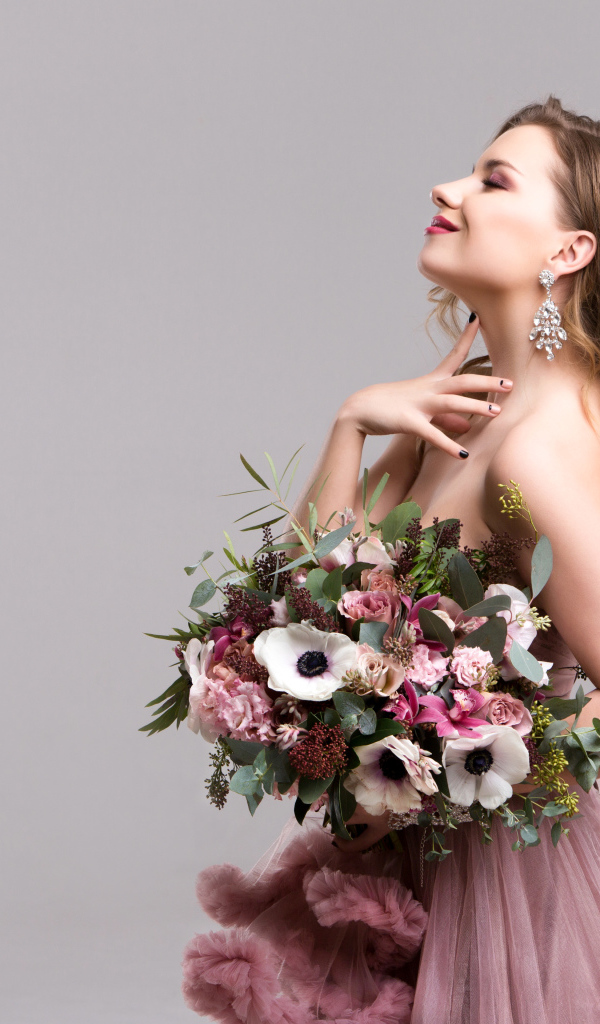 Нежная мечтательная девушка с букетом цветов анемоны