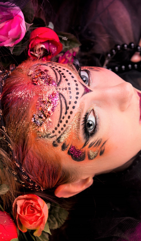 Девушка с блестящим ярким макияжем и розами в волосах
