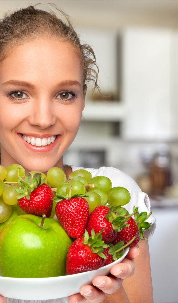 Улыбающаяся девушка со свежими фруктами 