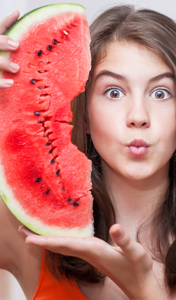 Девушка держит в руках скибку арбуза
