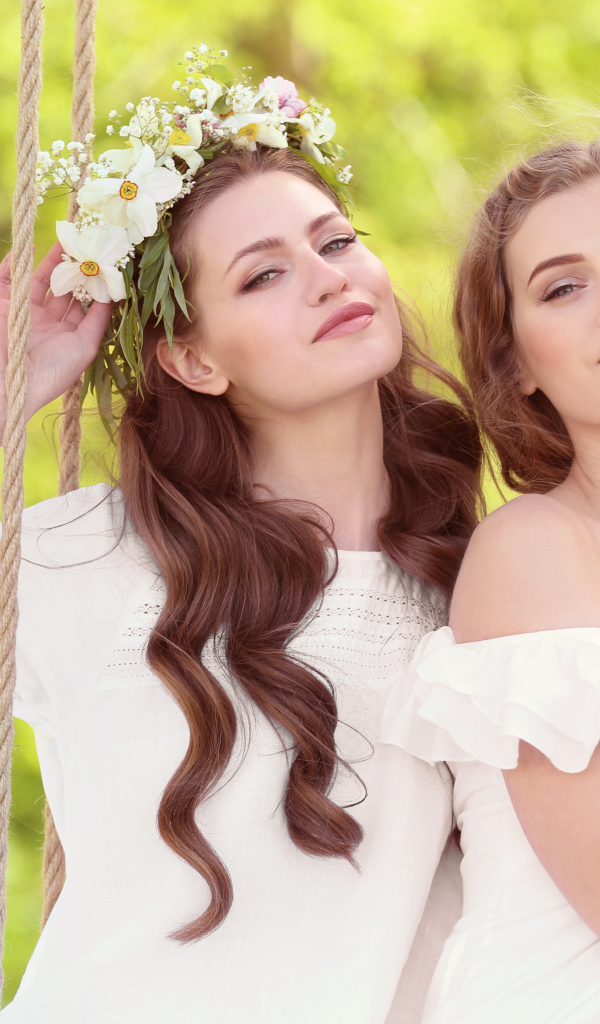 Две красивые длинноволосые девушки шатенки на качели