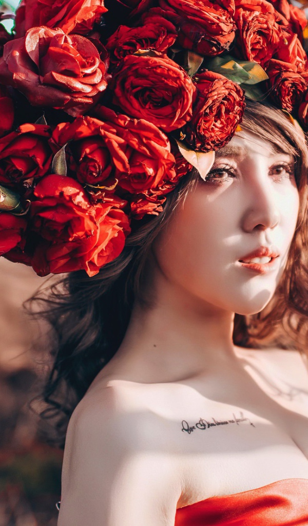 Молодая девушка азиатка с красными цветами на голове