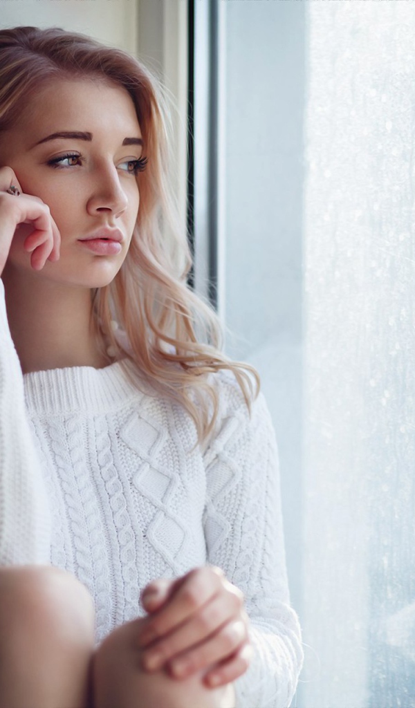 Молодая девушка блондинка у окна 