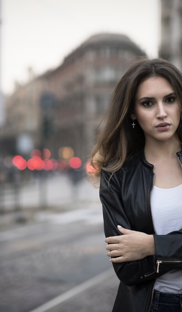 Молодая брюнетка в черной кожаной куртке