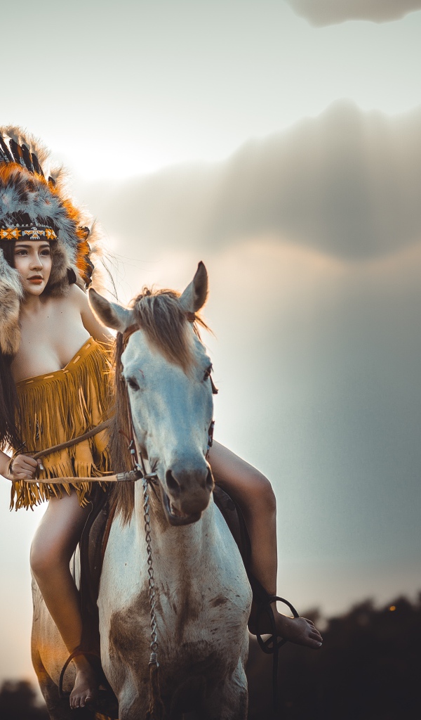 Молодая девушка в костюме индейца на коне