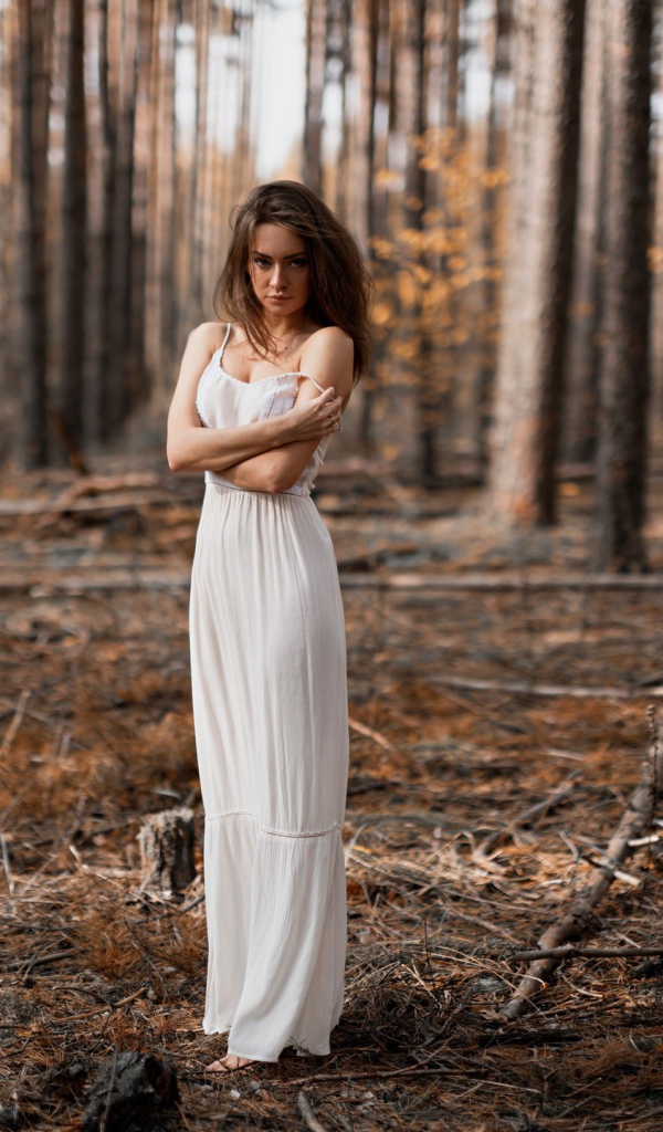 Молодая девушка в белом платье в лесу 