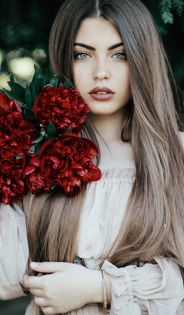 Молодая девушка с букетом бордовых пионов 