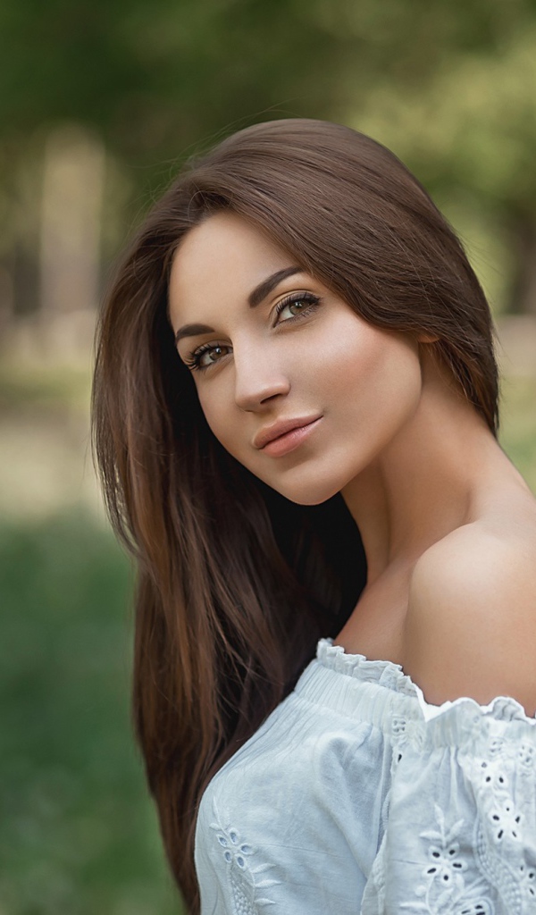 Молодая девушка с длинными волосами в белом 