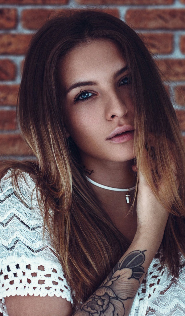 Молодая девушка с татуировкой на руке