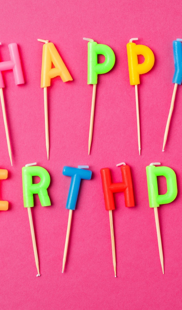 Праздничные свечи с надписью Happy Birthday на розовом фоне