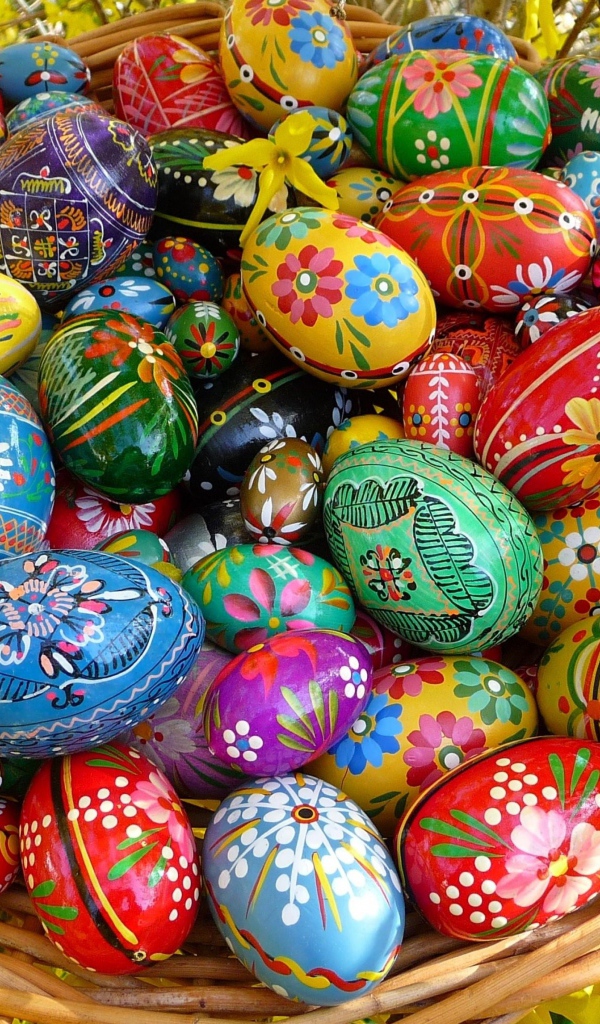 Яркие расписные пасхальные яйца в корзине 