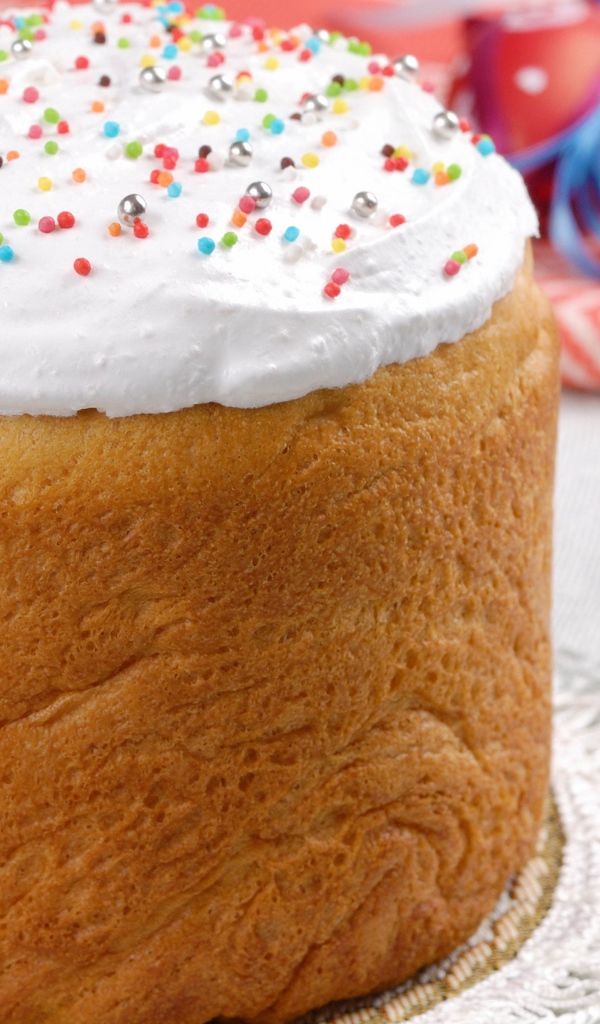 Пасхальный кулич с белой глазурью на столе 