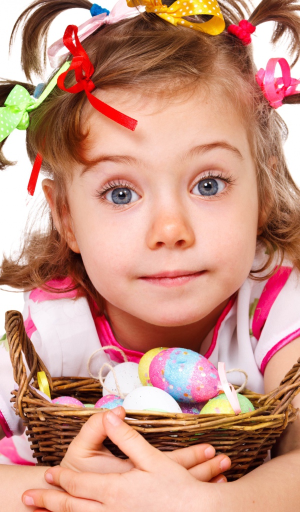 Маленькая девочка с корзинкой пасхальных яиц на белом фоне 
