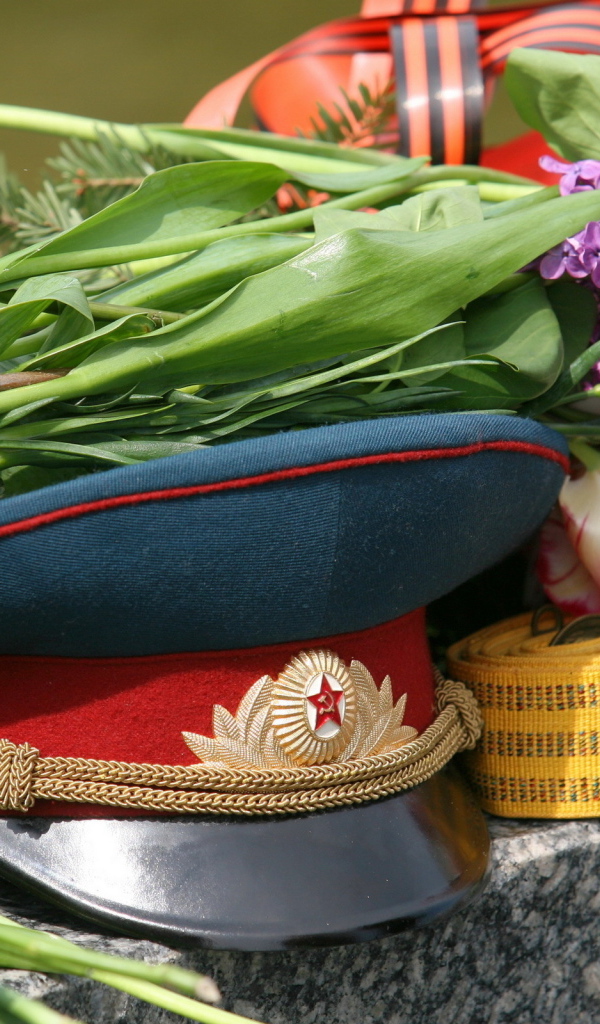 Военная фуражка и цветы на День Победы 9 мая 