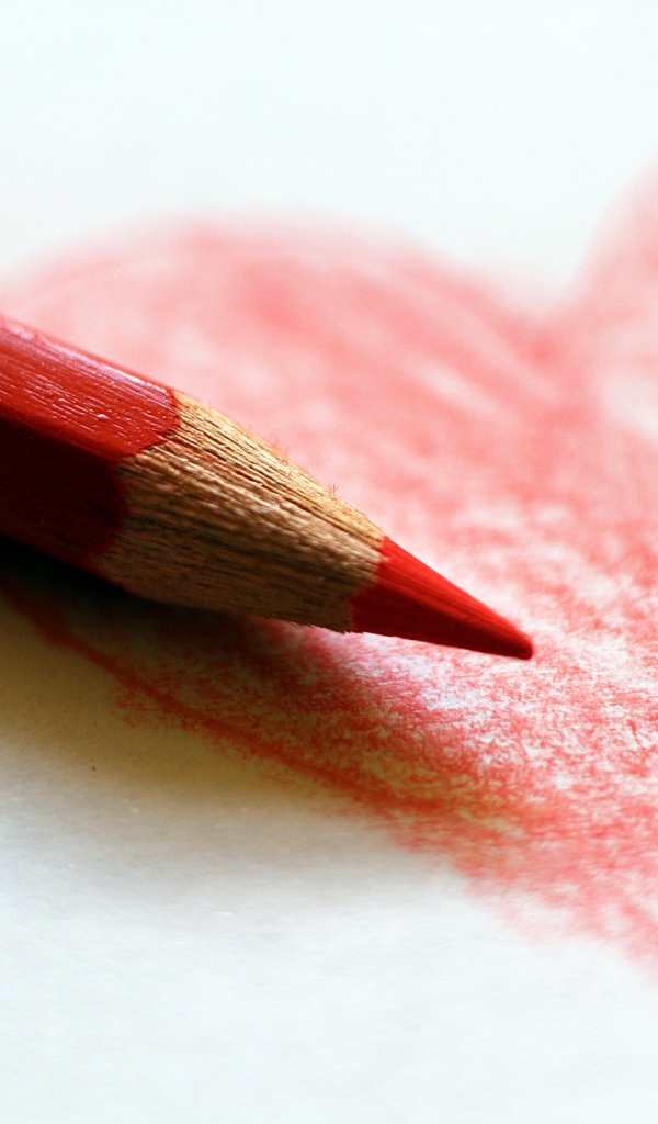 Нарисованное карандашом красное сердце на бумаге