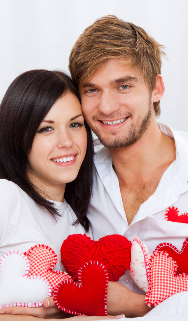 Красивая влюбленная пара с маленькими сердечками в руках