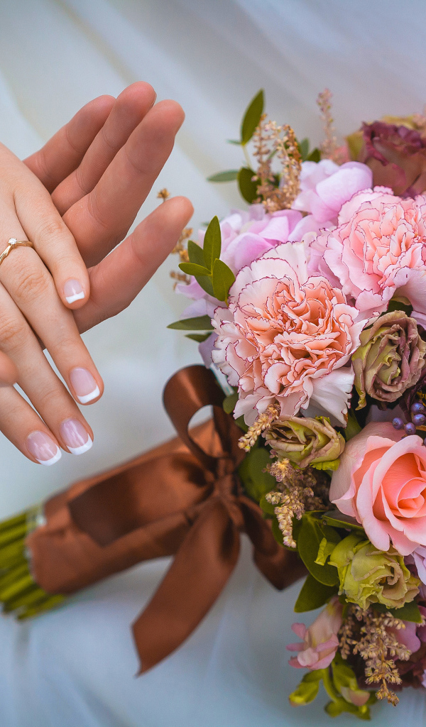 Руки влюбленной пары со свадебный букетов