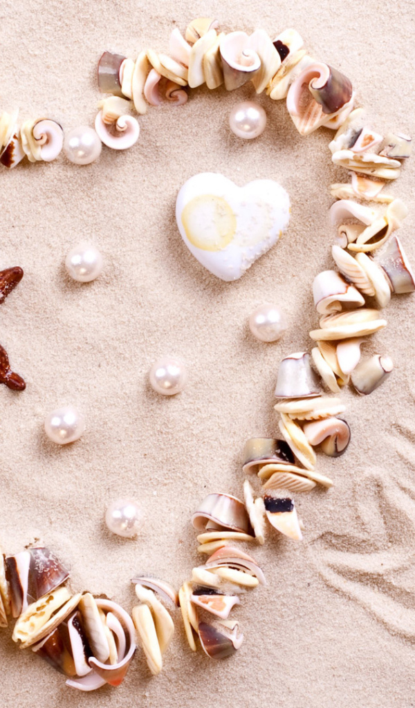 Сердце из ракушек на песке  