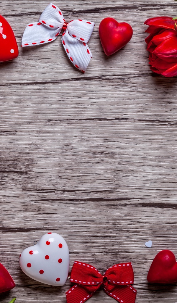 Красные тюльпаны с сердечками и бантиками на деревянной поверхности