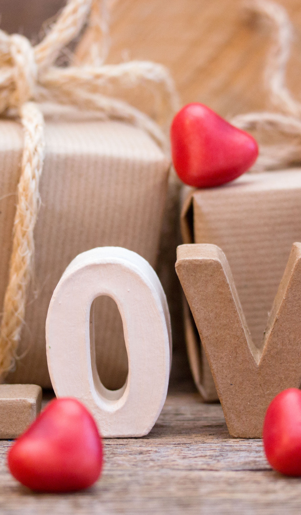 Романтические подарки и надпись Love с красными сердечками