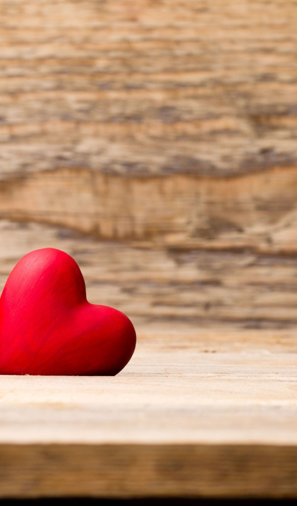 Два красных сердца лежат на деревянной лавке