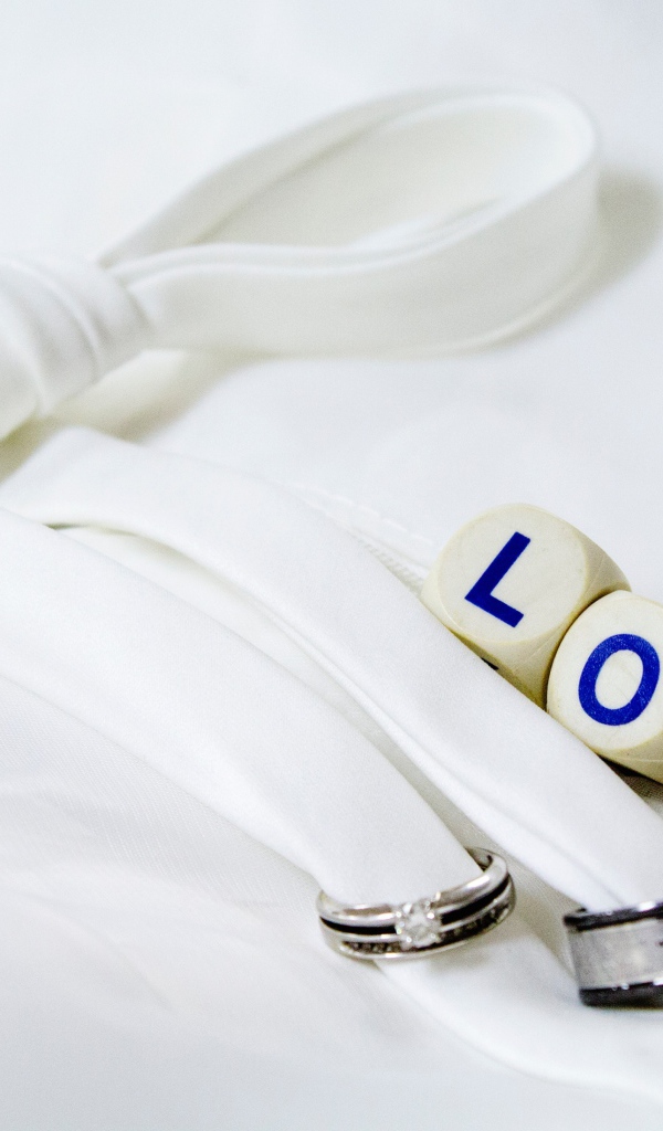 Два кольца перевязанные белой лентой и кубики с надписью любовь