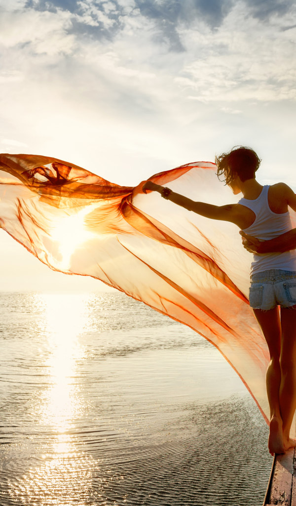 Молодая влюбленная пара гуляет у моря на закате