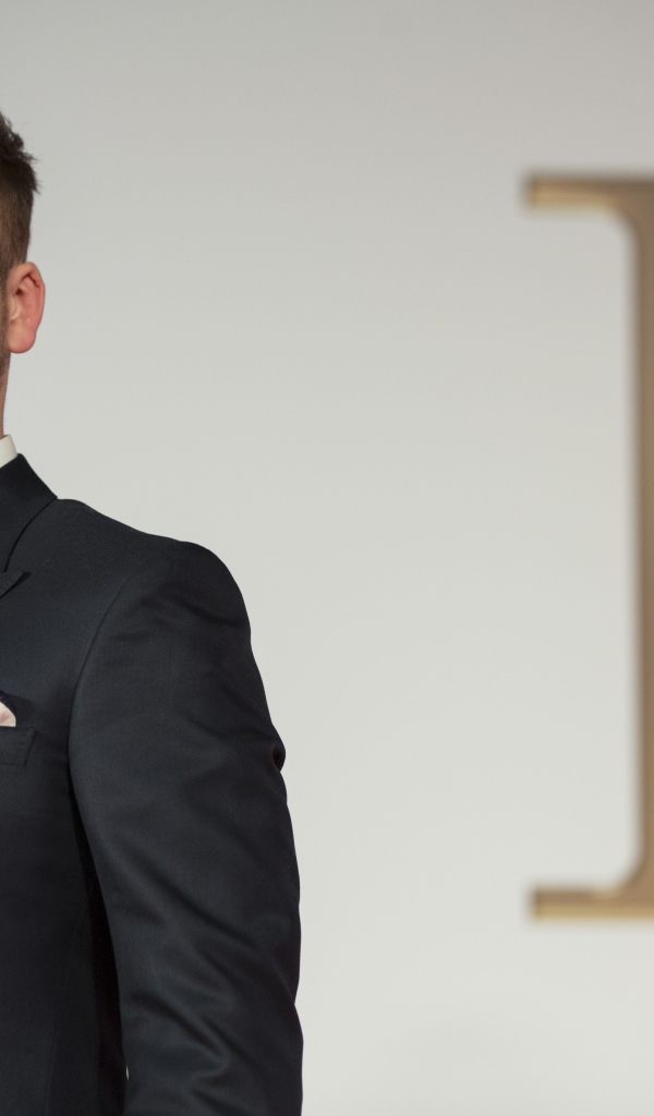 Молодой актер Терон Эгертон в черном пиджаке