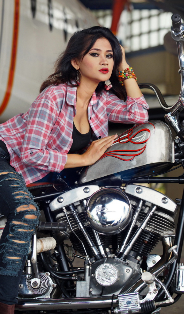Young asian girl in jeans on a motorcycle
