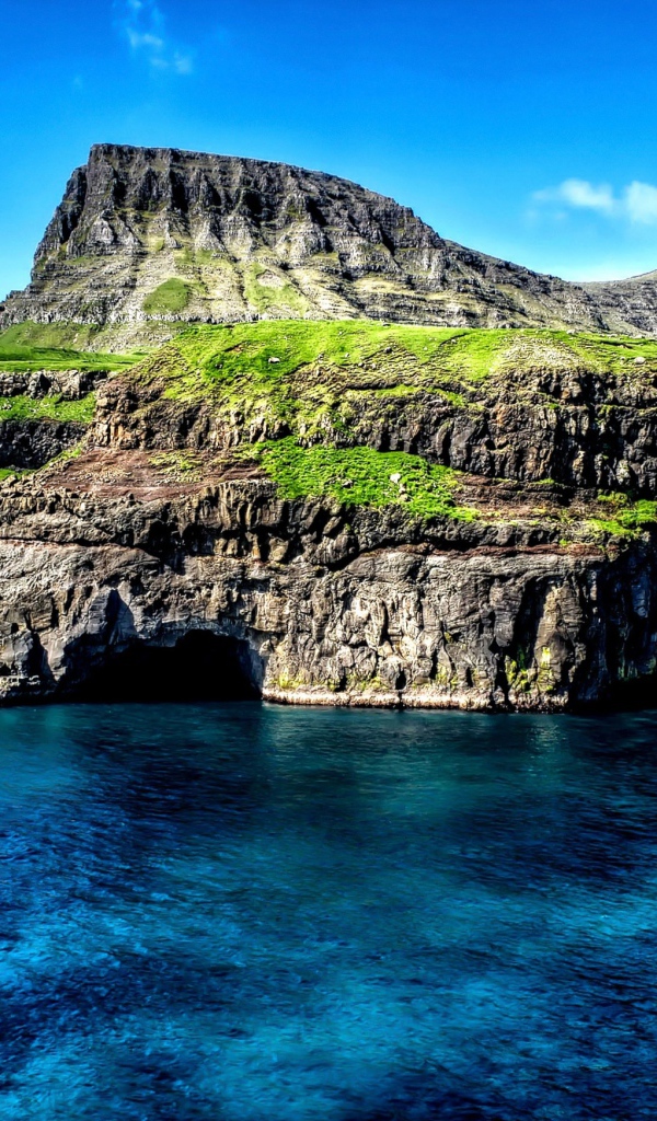 Маленький водопад стекает со скалы в океан, Гавайские острова