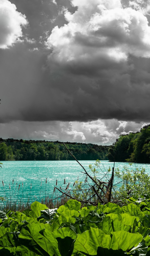 Голубая вода в озере на фоне дождевых облаков 