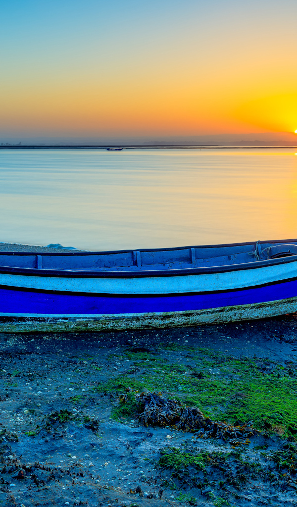 Лодка на берегу реки на закате солнца