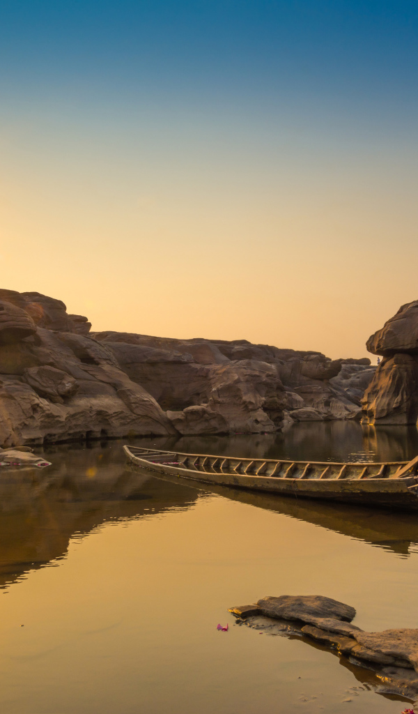 Лодна на озере между скал на рассвете