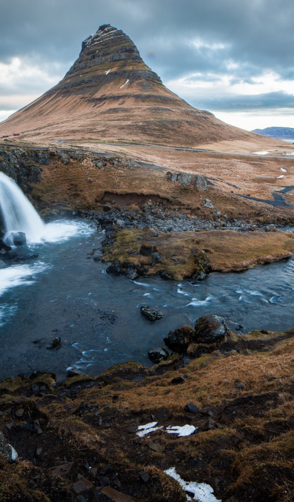 Гора и водопад у реки в Исландии  