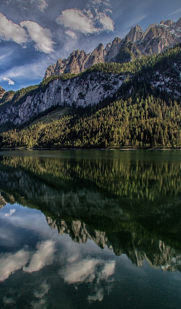 Сосны и горы отражаются в озере  