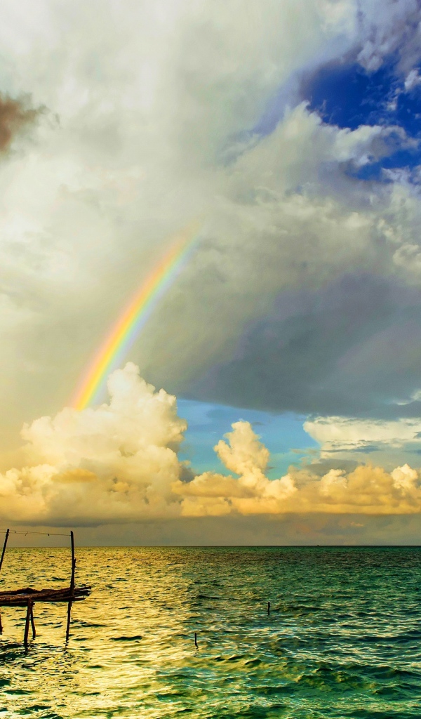 Радуга  над бунгало на тропическим пляжем 