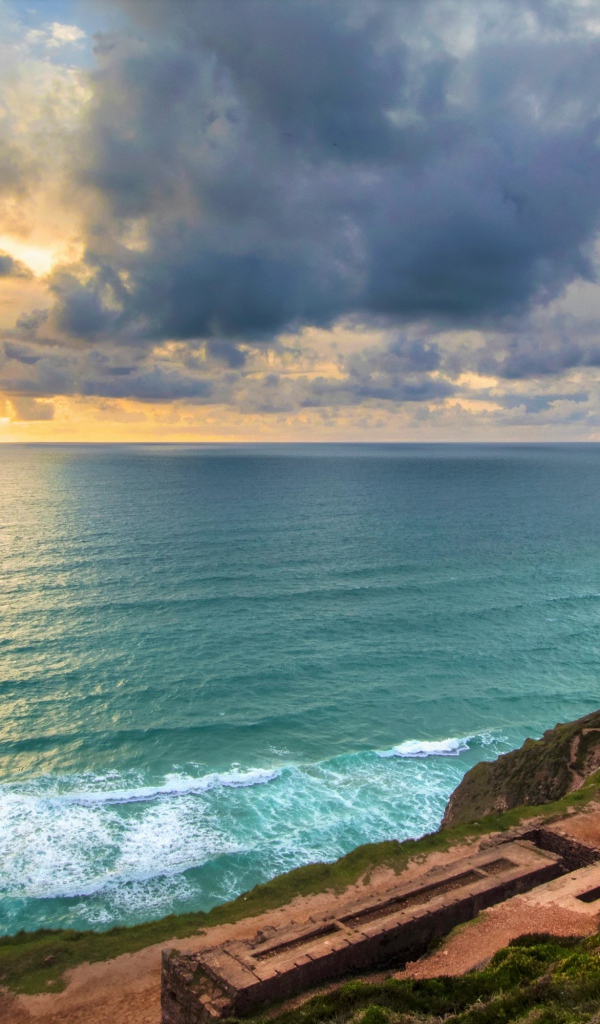 Руины здания на берегу океана под красивым  небом