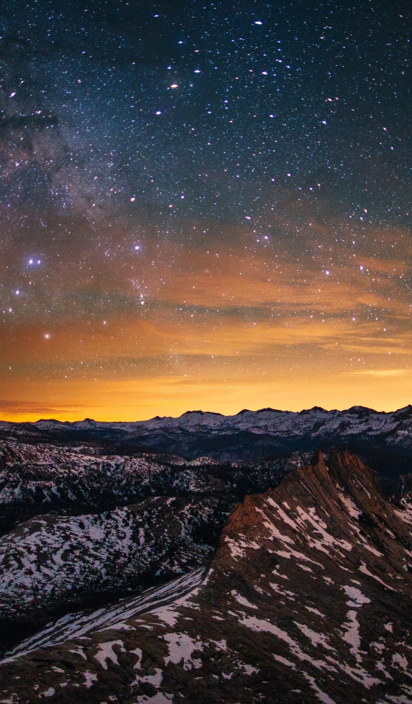 Звезды и млечный путь в небе над вершинами гор