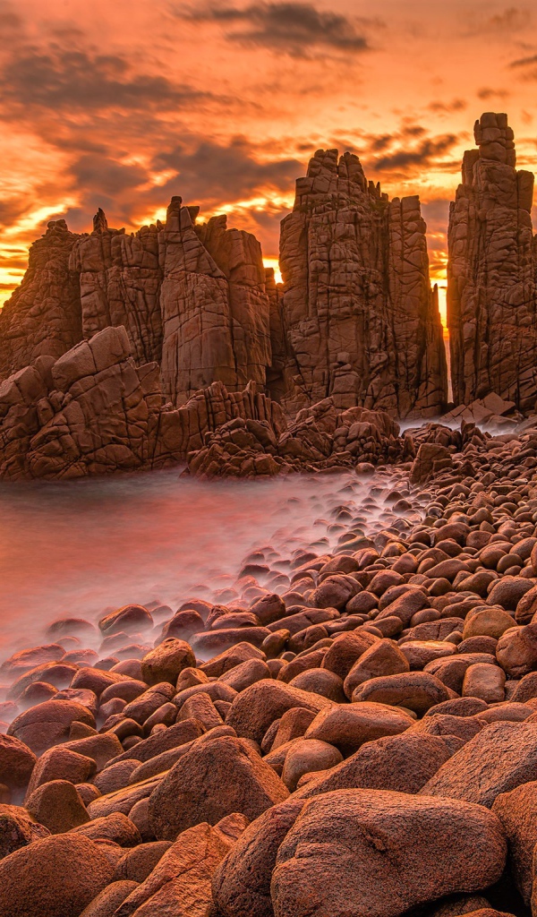 Каменные скалы в океане на закате солнца