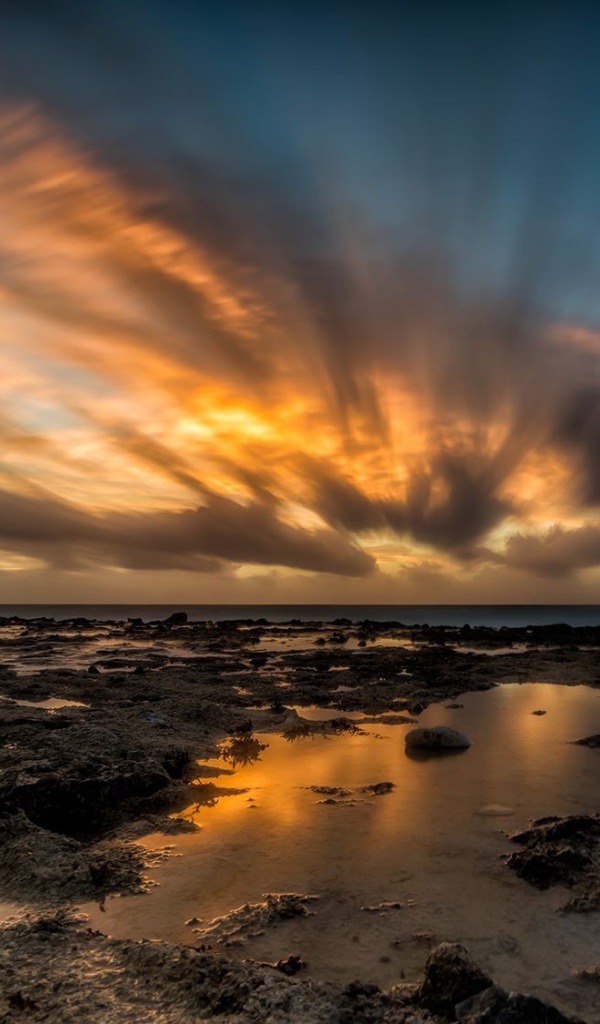 Закат солнца в облаках над водой 