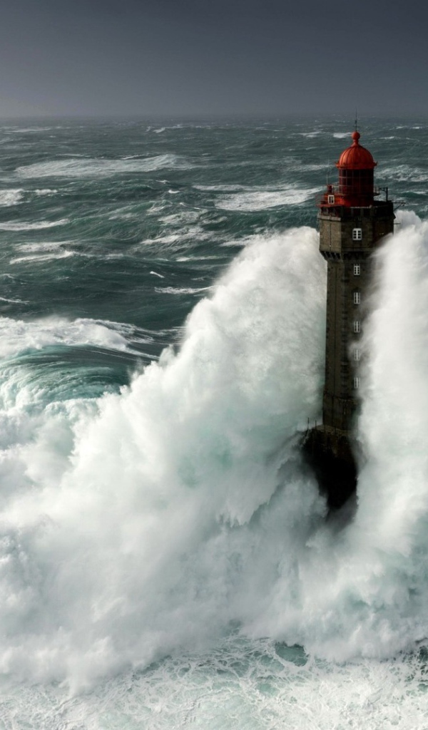 Бушующие волны окутывают маяк 